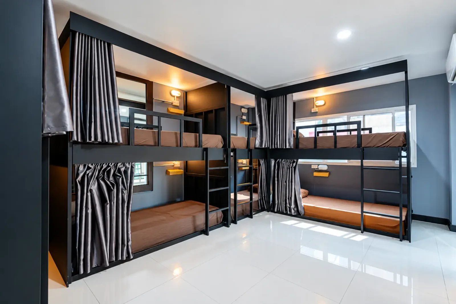 ห้องพักรวมคละชายหญิงของ Black Pantera Hostel มีเตียงสองชั้น ม่านกั้น และไฟอ่านหนังสือ